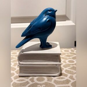 Blue bird figurine bookend on top of books